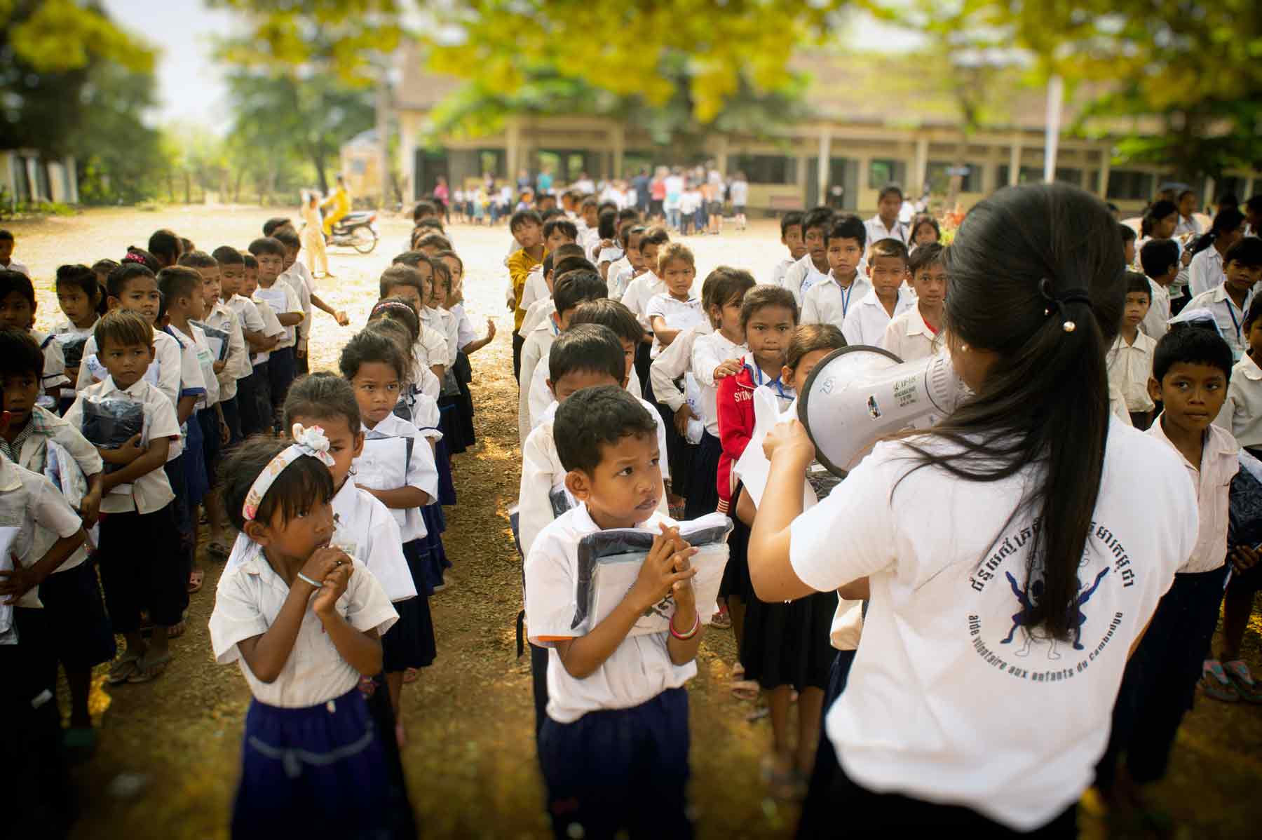 Junge Freiwillige in Kambodscha während einer humanitären Aktion im Bildungsbereich mit Hunderten von Kindern in einer öffentlichen Schule.