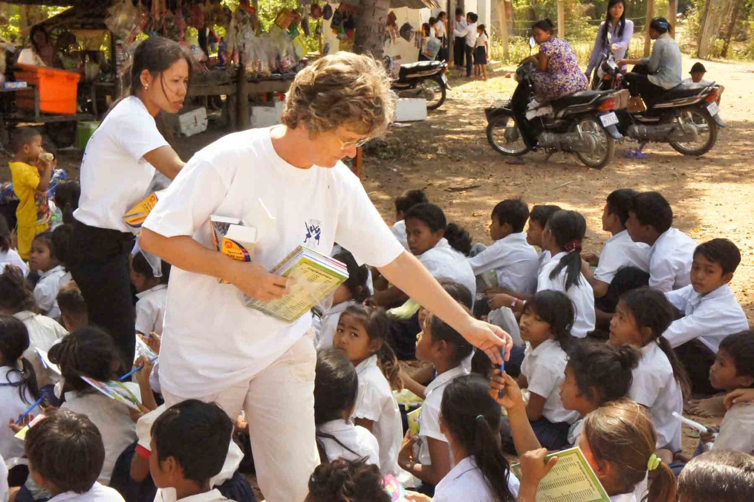 La neuchâteloise Nicole Reinhardt distribue du matériel scolaire à des enfants dans une école