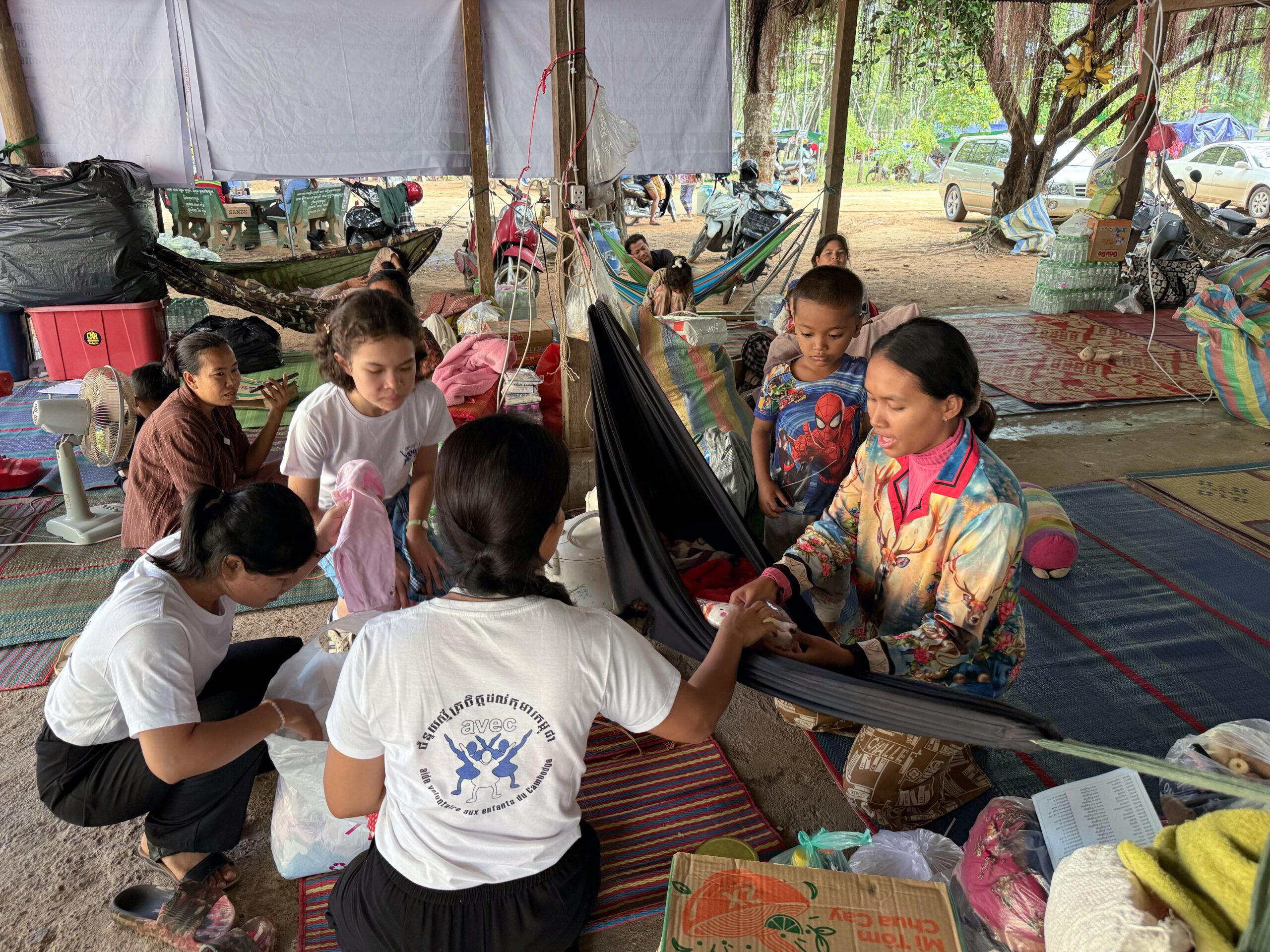 Les volontaires de l'ONG AVEC apportent de l'aide à une jeune maman cambodgienne ayant fuit les bombardements de l'armée Thaïlandaise et réfugiée dans un camp